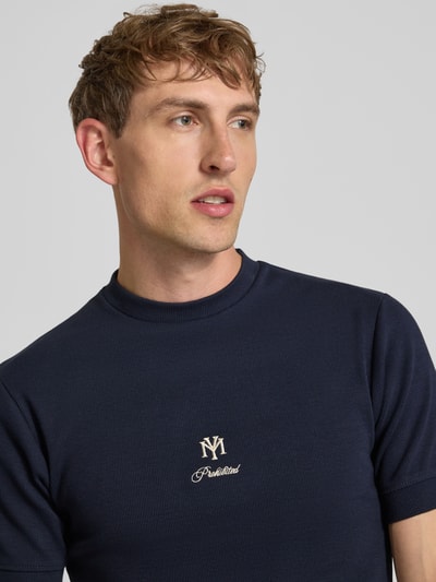 Męski model nosi Slim Fit T-Shirt mit Label-Stitching von PROHIBITED, mieszanka bawełny i elastanu, efekt prążkowania, okrągły dekolt, długość tyłu w rozmiarze M: 64 cm, kolor granatowy, zbliżenie na górną część ciała.