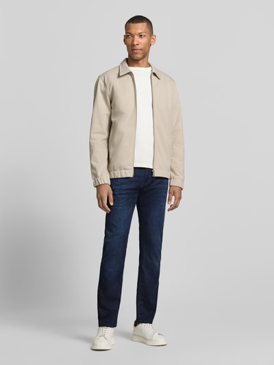 Männermodel trägt Jeans mit Eingrifftaschen Modell 'Lyon' von Pierre Cardin, Dunkelblau, Baumwoll-Mix mit Stretch-Anteil, Tapered-Fit, Ganzkörperansicht von vorne.