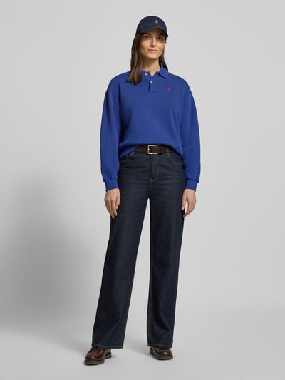 Frauenmodel trägt Regular Fit Sweatshirt aus Baumwoll-Mix von Polo Ralph Lauren in Unifarbe Blau mit Logo-Stitching, Ganzkörperansicht von vorne.