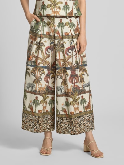 Frauenmodel trägt Wide Leg Hose im Allover-Look von MORE & MORE aus reiner Baumwolle, bunter Tier- und Pflanzenprint, elastischer Bund, Nahaufnahme Unterkörper.