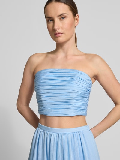 Kobieta modelka nosi top bandażowy z marszczeniami od Jake*s Cocktail z mieszanki lyocellu i lnu, dopasowany krój, jasnoniebieski, długość tyłu w rozmiarze 36: 23 cm, zbliżenie na górną część ciała.