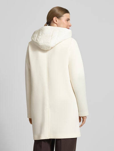 Modelka nosi Płaszcz mit Kapuze und Pattentaschen von Christian Berg Woman Selection, mieszanka materiałów z dodatkiem wiskozy, krój regular fit, kaptur z tunelem, listwa guzikowa, kieszenie z patką, kolor kremowy, gładka faktura, długość tyłu w rozmiarze 36: 88 cm, szerokość ramion w rozmiarze 36: 45 cm, szerokość klatki piersiowej w rozmiarze 36: 50 cm, długość rękawów w rozmiarze 36: 57 cm, całkowity widok z tyłu