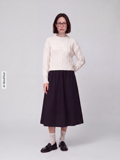 Vrouwenmodel draagt Regular Fit Pullover aus reiner Schurwolle model 'ALBEN' van Weekend Max Mara in crème met kabelpatroon, zwarte rok, Ganzkörperansicht van voren, KI-modificeerd beeld.