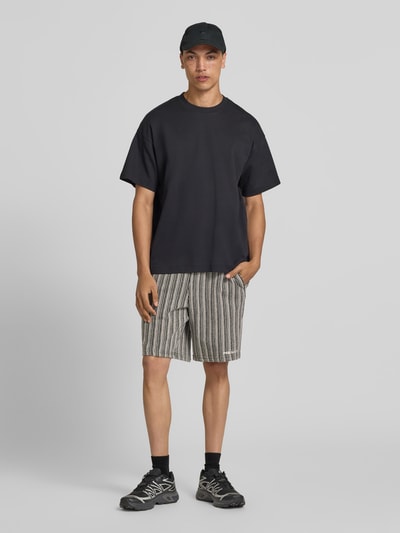 Männermodel trägt Straight Fit Shorts mit Strukturmuster Modell 'Forno' von Pegador aus Reine Baumwolle, Ganzkörperansicht von vorne.