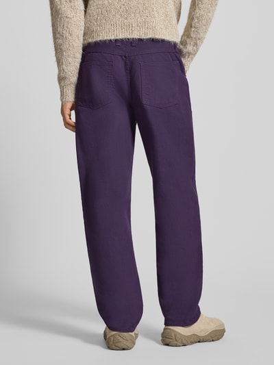 Männermodel trägt Loose Fit Jeans mit Eingrifftaschen Modell 'DOUBLE KNEE TYRELL PANT' von Edwin in Lila, Baumwollstruktur, Ganzkörperansicht Rückansicht.