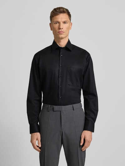 Männermodel draagt Comfort Fit Business Hemd aus Baumwolle mit Kentkragen van ETERNA in zwart, met borstzak en knoopsluiting, Ganzkörperansicht von vorne.