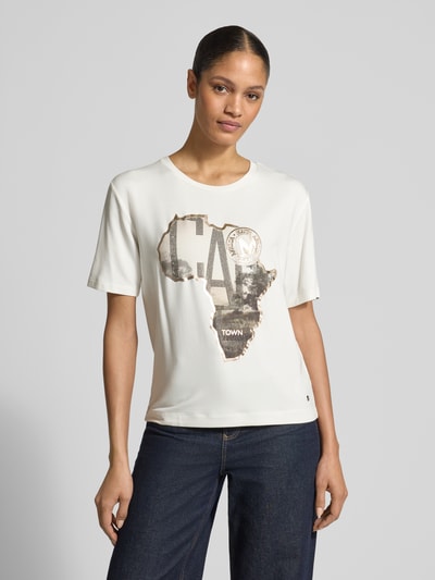 Vrouwenmodel draagt T-Shirt met Motiv-Print van monari, viscosemix met modal, regular fit, met ronde hals, print en sierstenen, voorkant bovenlichaam dichtbij.