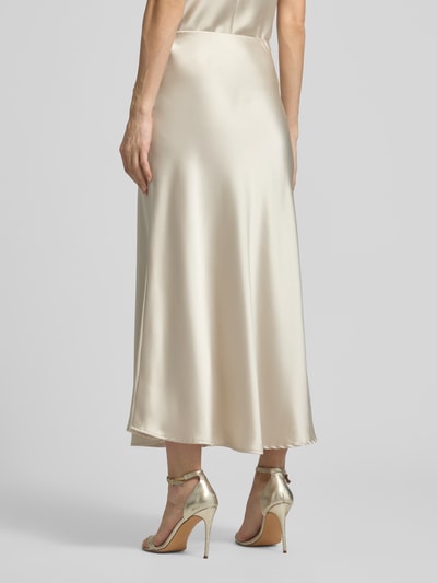Frauenmodel trägt Midirock mit Stretch-Anteil Modell 'Fabiola' von GUIDO MARIA KRETSCHMER WOMAN, Satin, A-Linie, Midilänge, Rückansicht.
