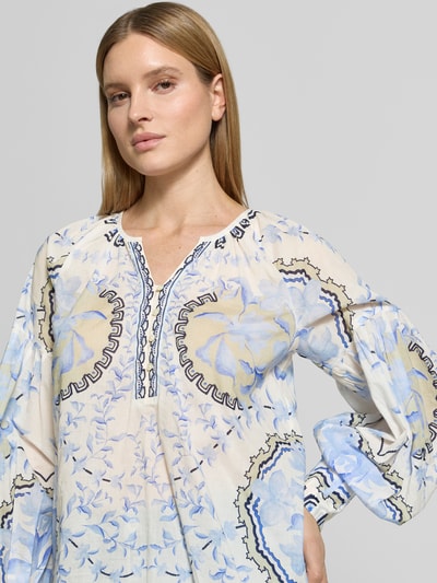 Frauenmodel trägt Relaxed Fit Bluse mit Tunika-Ausschnitt Modell 'Wylde' von MOS MOSH aus reiner Baumwolle, floraler Allover-Print in Blau, Langarm, Nahaufnahme Oberkörper.