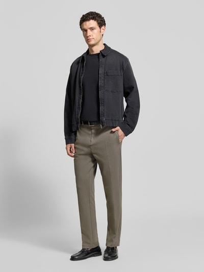 Männermodel trägt Regular Fit Sweathose aus Baumwoll-Mix von Marc O'Polo in Beige, kombiniert mit schwarzer Jacke, Ganzkörperansicht von vorne. Herren Sweathose von Marc O'Polo.