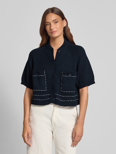 Frauenmodel trägt Regular Fit Cardigan mit Viskose-Anteil von Stefanel in dunkler Strick-Optik, mit Stehkragen, Halbarm und aufgesetzten Taschen, Material-Mix, elastische Abschlüsse, Ganzkörperansicht von vorne.