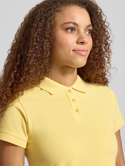 Frauenmodel trägt kurzärmliges Poloshirt in Piquéoptik mit Kragen und Logostickerei von REVIEW, reine Baumwolle, Slim Fit, Nahaufnahme Oberkörper.