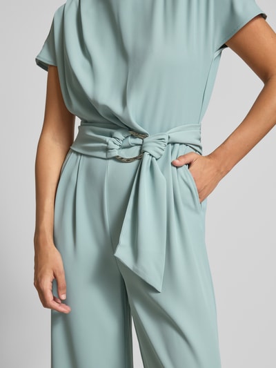 Frauenmodel trägt Jumpsuit mit Stretch-Anteil von Betty Barclay in Mint, Elastischer-Material-Mix, Regular-Fit, Gürtel, Gelegte Falten, Nahaufnahme Oberkörper.