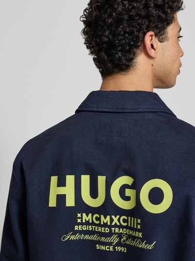 Männermodel trägt Regular Fit Hemdjacke aus reiner Baumwolle Modell 'BIYO' von HUGO in Dunkelblau, Label-Print, Twill, Rückansicht