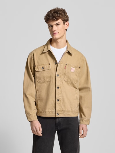 Männermodel trägt Jacke mit Knopfleiste von Levi's®, Reine Baumwolle, Regular-Fit, Kentkragen, Brusttaschen, Label-Detail, Eingrifftaschen, beige, glatte Optik, Ganzkörperansicht von vorne.