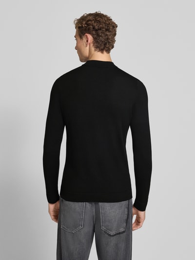 Männermodel trägt schwarzen Slim Fit Longsleeve aus reiner Schurwolle Modell 'Arwon' von DRYKORN, texturierte Oberfläche, Ganzkörperansicht Rückansicht. Rückenlänge 67 cm, Ärmellänge 68 cm.