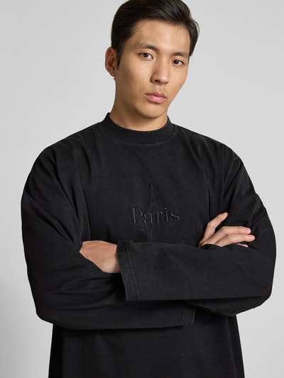 Männermodel trägt Regular Fit Sweatshirt aus Baumwolle von VETEMENTS in Schwarz mit Stehkragen, Statement-Stitching, Langärmelig, Nahaufnahme Oberkörper. Rückenlänge bei Größe M: 80 cm.