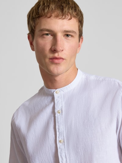 Männermodel trägt Regular Fit Freizeithemd aus Baumwoll-Leinen-Mix von Jack & Jones in Weiß mit Stehkragen, Nahaufnahme Oberkörper.