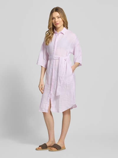 Kobiece model prezentuje Leinenkleid aus reinen Leinen Modell 'Derby' od 0039 Italy, jasnoróżowy, len, taliowany krój, rękaw o dł. 1/2, wykładany kołnierz, listwa guzikowa, półprzezroczysty materiał, odpinana materiałowa tasiemka, długość tyłu w rozmiarze S: 96 cm, szerokość w rozmiarze S: 59 cm, długość rękawów w rozmiarze S: 24 cm, widok całej sylwetki z przodu