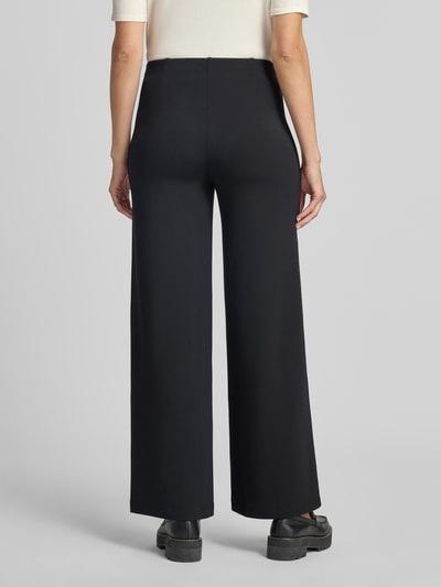 Frauenmodel trägt Wide Fit Hose mit Ziernähten von Christian Berg Woman, schwarze Farbe, elastischer Bund, Ganzkörperansicht Rückansicht.
