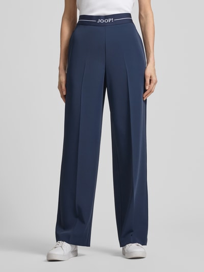 Kobiece modelka nosi Hose mit elastischem Bund und Label-Detail von JOOP!, mieszanka materiałów z dodatkiem streczu, krój regular fit, elastyczny pas, detal z logo, szerokość w rozmiarze 36: 38 cm, długość wewnętrzna nogawki w rozmiarze 36: 81 cm, ciemnoniebieski, proste nogawki, gładka tekstura, widok całej sylwetki z przodu.