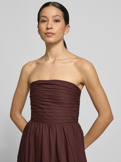 Modelka kobieca nosi sukienkę midi z odkrytymi ramionami model 'Matisse Ruched' od Forever New, bawełna, linia a, kolor bordowy, szerokość w rozmiarze 36: 40 cm, długość tyłu w rozmiarze 36: 110 cm, zbliżenie na górną część ciała.