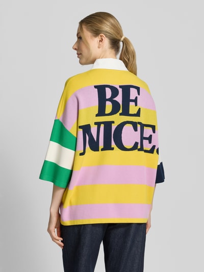 Frauenmodel trägt koszulka polo Oversized Poloshirt aus Viskose-Mix Modell 'JICE STRIPED EMBO' von Essentiel Antwerp, efekt: wielokolorowy, krój: oversized, wzór: w paski, aplikacje z motywem, detal: tekst, kołnierzyk polo, zapięcie: krótka listwa guzikowa, rękaw o dł. 3/4, zakończenie rękawów i wykończenie: prążkowane, wykończenie materiału: drobny splot, materiał: mieszanka wiskozy. Ganzkörperansicht Rückansicht.