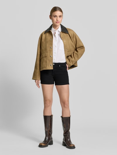 Frauenmodel trägt Regular Fit Jeansshorts aus Baumwoll-Mix Modell 'LUNA' von Vero Moda in schwarzer Denim-Optik, 5-Pocket-Design, Ganzkörperansicht von vorne.
