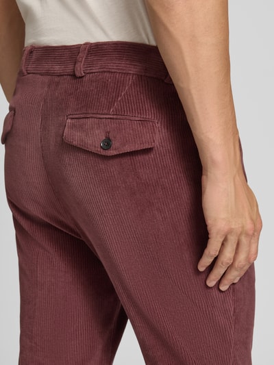 Männermodel trägt Slim Fit Hose aus Baumwoll-Mix in Cord-Optik Modell 'Cliffer' von Zuitable, rotbraune Struktur, Detailaufnahme Gesäßbereich. Elastischer Baumwoll-Mix, Eingriff- und Gesäßtaschen, Knopf- und Reißverschluss, Bundweite 37 cm, Innenbeinlänge 76 cm.