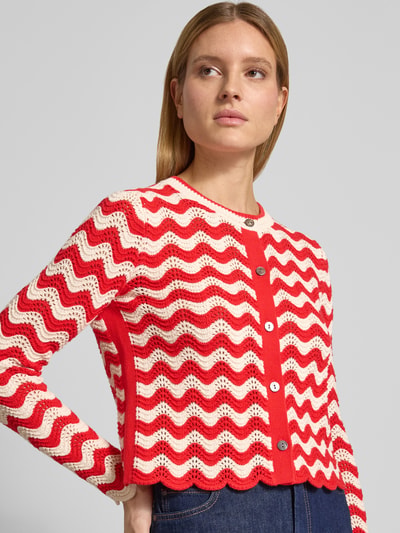 Frauenmodel trägt Strickjacke im Allover-Look mit Rundhalsausschnitt von Christian Berg Woman aus Reine Baumwolle, Regular-Fit, rot-weiß gemustert, mit Knopfleiste, Rückenlänge bei Größe S 53 cm, Ärmellänge 66 cm, Nahaufnahme Oberkörper.