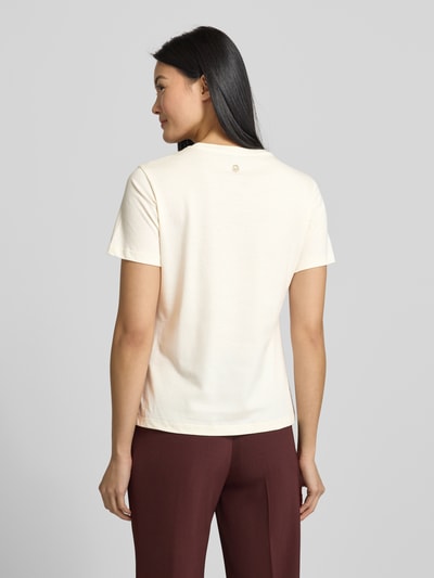 Frauenmodel trägt T-Shirt mit Label-Print Modell 'Tanna' von JOOP! aus reiner Baumwolle im Regular-Fit, Farbe Creme, Rückansicht Ganzkörperansicht.