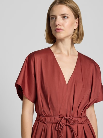 Frauenmodel trägt Cocktailkleid mit V-Ausschnitt und Schnürung von Christian Berg Cocktail, rostrot, Baumwoll-Elasthan-Mix, Nahaufnahme Oberkörper.