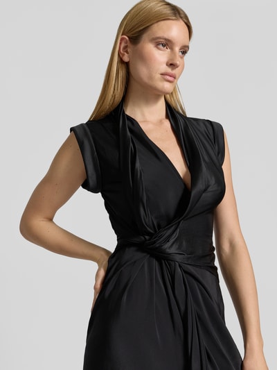 Frauenmodel trägt Midikleid aus Viskose-Mix von Victoria Beckham in Schwarz, taillierte Passform mit Raffungen, Nahaufnahme Oberkörper.