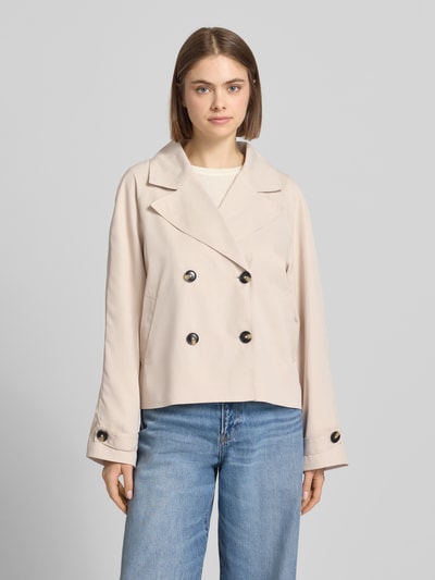 Frauenmodel trägt Regular Fit Trenchcoat mit breitem Reverskragen Modell 'SCARLETT' von Pieces, Optik: Unifarben, Cropped-Länge, doppelreihige Knopfleiste, Langarm, seitliche Eingrifftaschen, Ganzkörperansicht von vorne.