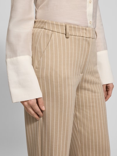 Frauenmodel trägt Hose mit Bügelfalten und Gesäßtaschen von Comma aus Material-Mix mit Viskose-Anteil, Regular-Fit, Nahaufnahme Oberkörper.