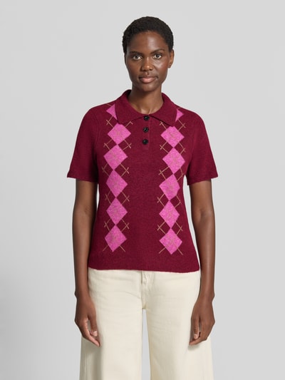 Frauenmodel trägt Slim Fit Poloshirt mit Woll-Anteil Modell 'Dasila' von ICHI, Strick-Optik, bordeaux mit rosa Muster, Ganzkörperansicht von vorne.