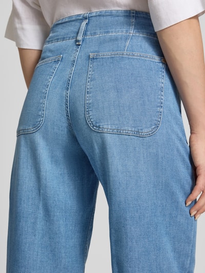 Frauenmodel trägt Wide Leg Jeans aus Baumwoll-Mix Modell 'STYLE.MAINE' von Brax in Denim-Optik, Label-Applikation aus Metall, Detailaufnahme Rückansicht.