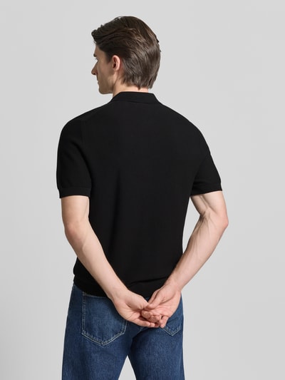 Mężczyzna-model nosi Regular Fit Poloshirt aus reiner Baumwolle od Lacoste, czarny kolor, krój regular fit, krótki rękaw, widok całej sylwetki z tyłu.