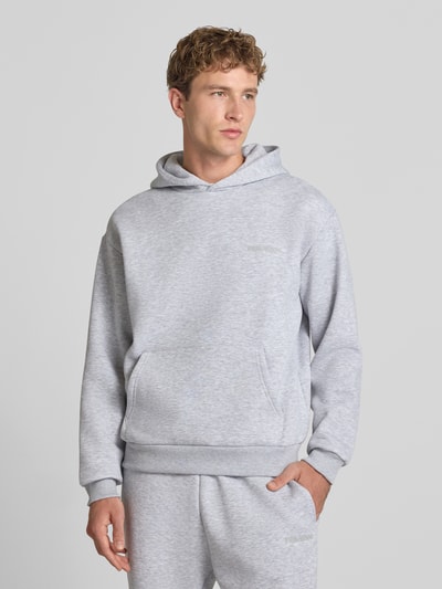 Männermodel trägt Regular Fit Hoodie aus Baumwoll-Mix von REVIEW in Hellgrau mit Känguru-Tasche, elastischen Abschlüssen, Nahaufnahme Oberkörper.