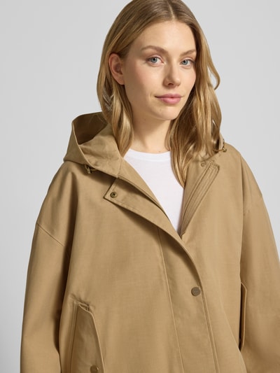 Frauenmodel trägt Jacke mit Kapuze und versiegelten Nähten Modell 'ELLE' von G-LAB aus Lyocell-Mix mit Leinen-Anteil in Beige, Nahaufnahme Oberkörper.