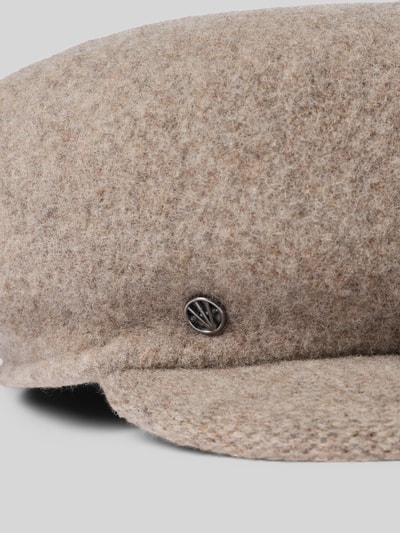 Produktfoto, Schiebermütze aus Wolle Modell 'Bakerboy' von Loevenich, beige meliert, grobe Wollstruktur, silbernes Label-Detail sichtbar.