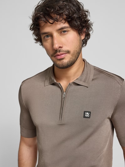 Männermodel trägt Regular Fit Poloshirt aus Viskose-Mix Modell 'SAYFONG-4' van HUGO, effen, label patch, polokraag, korte mouwen, jersey. Nahaufnahme Oberkörper.