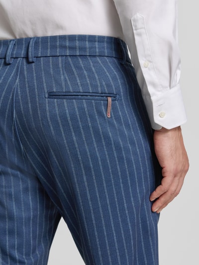 Mężczyzna nosi Slim Fit Anzughose mit Viskose-Anteil Modell 'Silvio' von CINQUE w kolorze niebieskim z białymi paskami, tekstura gładka, materiał elastyczny, kieszenie z tyłu, kontekst: krój slim fit, szerokość w rozmiarze 50: 48 cm, długość nogawki wewnętrznej w rozmiarze 50: 71 cm, detalowe ujęcie tylnej części.