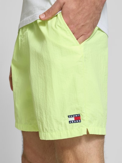 Männermodel trägt Regular Fit Sportshorts mit Tunnelzug von Tommy Jeans, Optik: Unifarben, Label-Patch, 5-Pocket-Design, Nahaufnahme Oberschenkel.