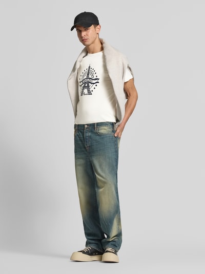 Männermodel trägt Slim Fit T-Shirt aus reiner Baumwolle von KENZO mit Motiv-Print und Label-Schriftzug in Weiß, Ganzkörperansicht von vorne.