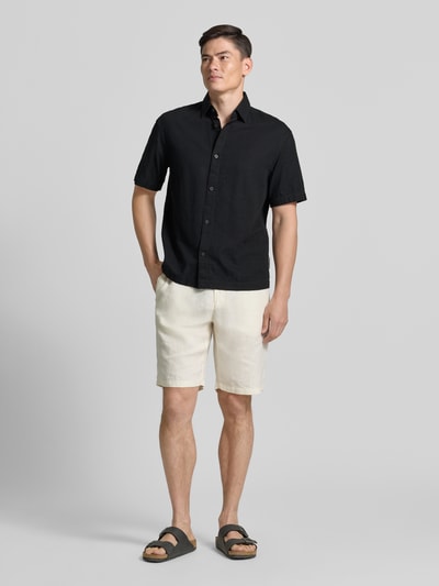 Männermodel trägt Loose Fit Freizeithemd aus reiner Baumwolle von Tom Tailor Denim, Optik: Unifarben, Kentkragen, einreihige Knopfleiste, kurzarm, Material: Reine Baumwolle, Ganzkörperansicht von vorne.