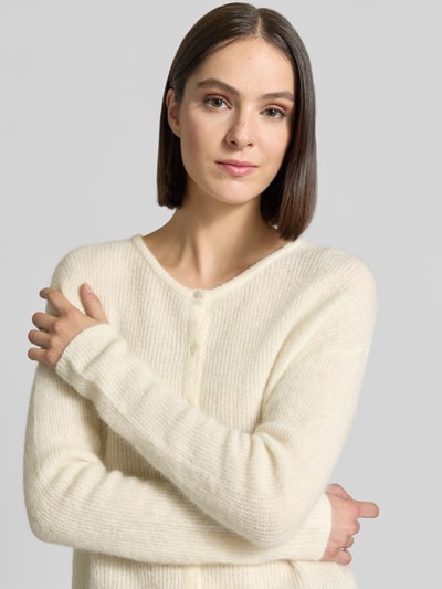 Frauenmodel trägt Regular Fit Strickjacke aus Woll-Alpaka-Mix Modell 'Almine' von MOS MOSH in Creme, feine Struktur, Nahaufnahme Oberkörper.