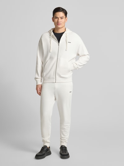 Männermodel trägt Relaxed Fit Sweatjacke aus reiner Baumwolle Modell 'DAPOZIP' von HUGO, Optik: Unifarben, Ganzkörperansicht von vorne.