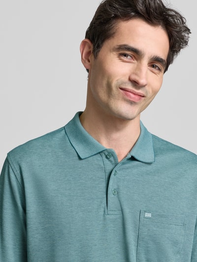 Männermodel trägt Regular Fit Poloshirt mit Brusttasche von Christian Berg Men aus Material-Mix mit Baumwoll-Anteil; Nahaufnahme Oberkörper.