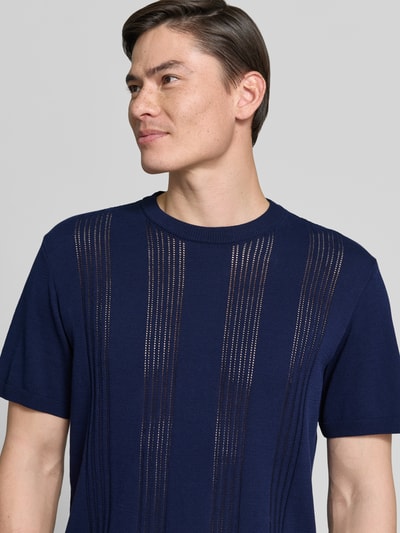 Männermodel trägt Relaxed Fit T-Shirt aus reiner Baumwolle von Armedangels in Optik: Unifarben, Feinstrick, Label-Patch, Nahaufnahme Oberkörper.